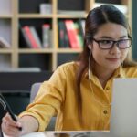woman wearing headphones engaged in online education