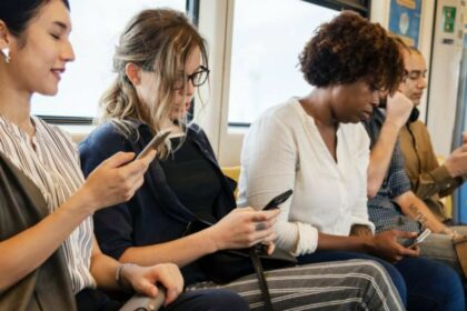 people on a metro train using smartphone