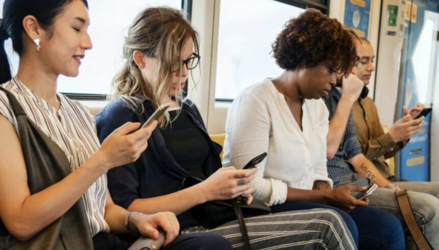people on a metro train using smartphone