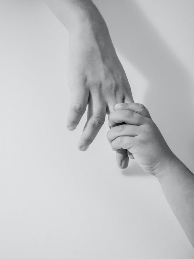 grayscale photo of to hands
