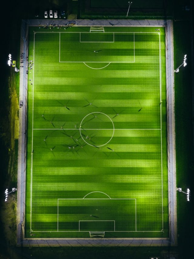 bird's-eye view photography of green soccer field with lights