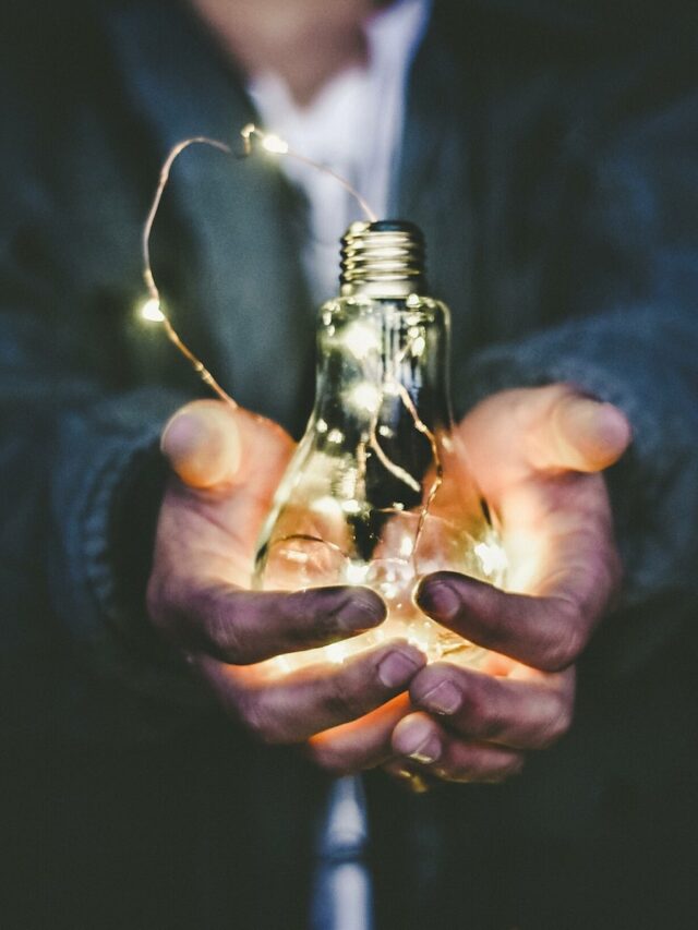 man holding incandescent bulb