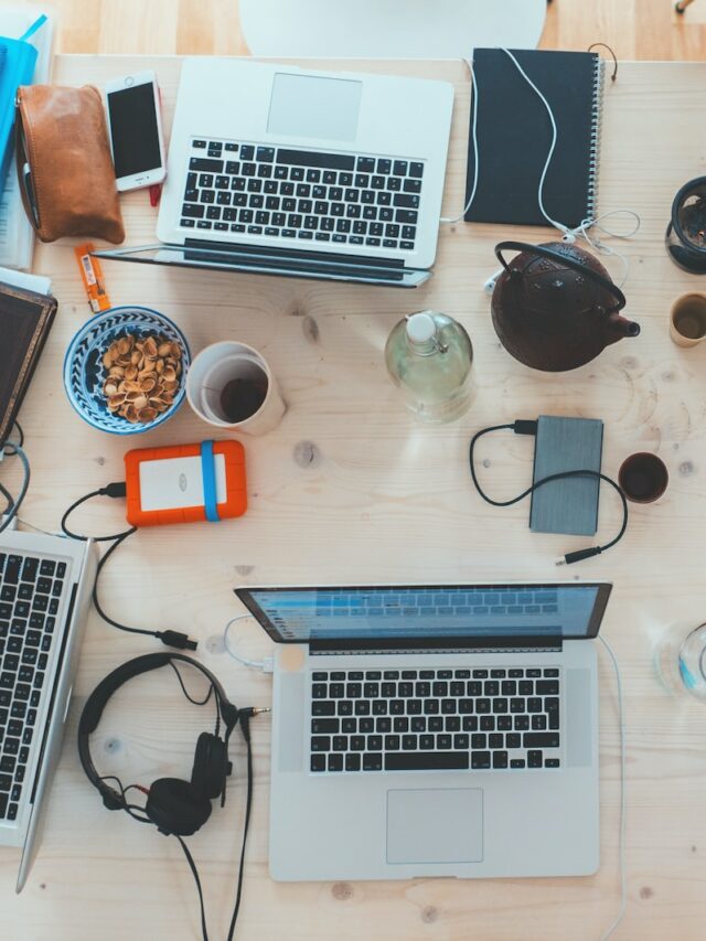 people sitting down near table with assorted laptop computers