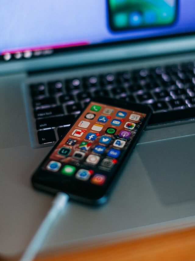 selective focus photography of iPhone on MacBook