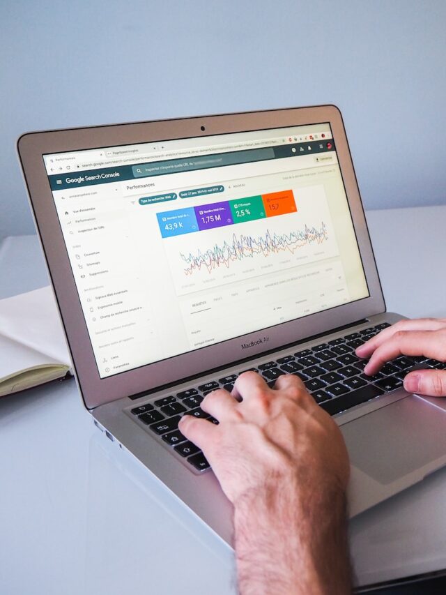 person using macbook air on white table