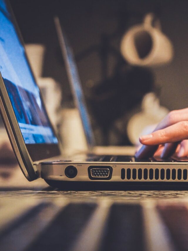 person using silver laptop computer on desk