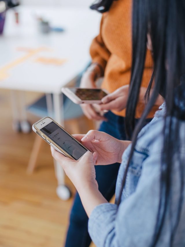 selective focus photography of woman holding phone
