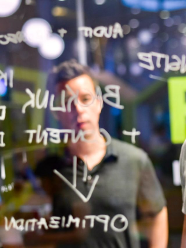 man writing on glass board