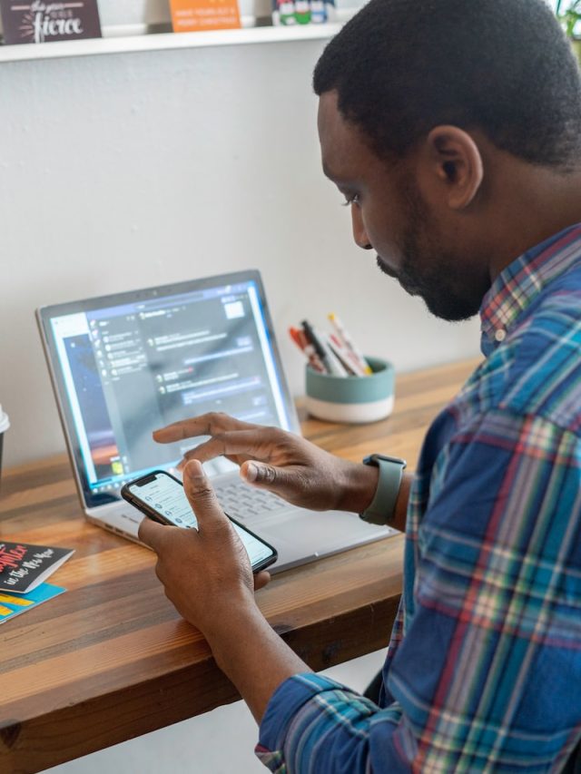 man in blue and red plaid dress shirt using silver ipad