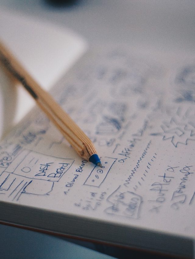 blue ballpoint pen on white notebook