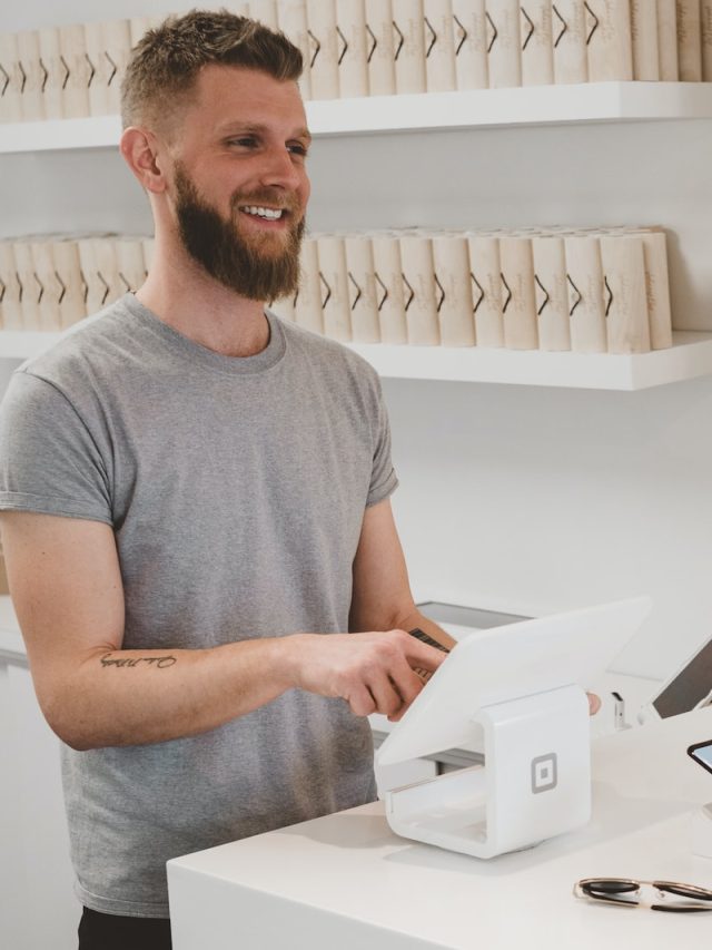 man in grey crew-neck t-shirt smiling to woman on counter