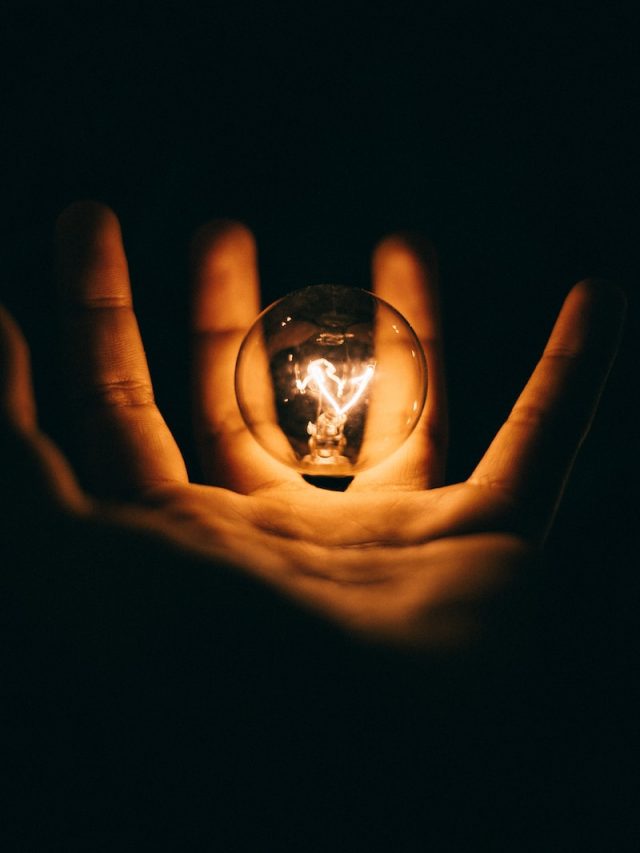 clear glass bulb on human palm