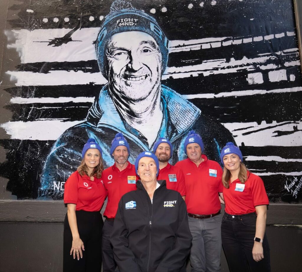 FightMND patron Neale Daniher with Coles team members at the unveiling of his mural in Melbourne CBD laneway'