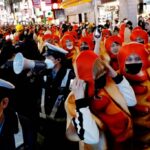 Police officers work to control a crowd gathering to celebrate Halloween in the Shibuya district of Tokyo on Oct 31, 2022 REUTERS