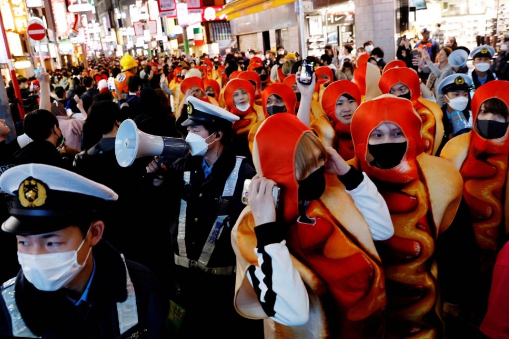 Police officers work to control a crowd gathering to celebrate Halloween in the Shibuya district of Tokyo on Oct 31, 2022 REUTERS