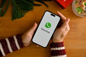 a female holding a smartphone with whatsapp logo