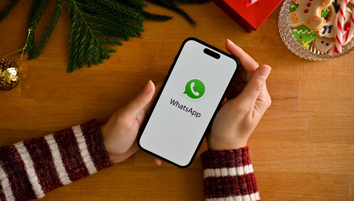 a female holding a smartphone with whatsapp logo