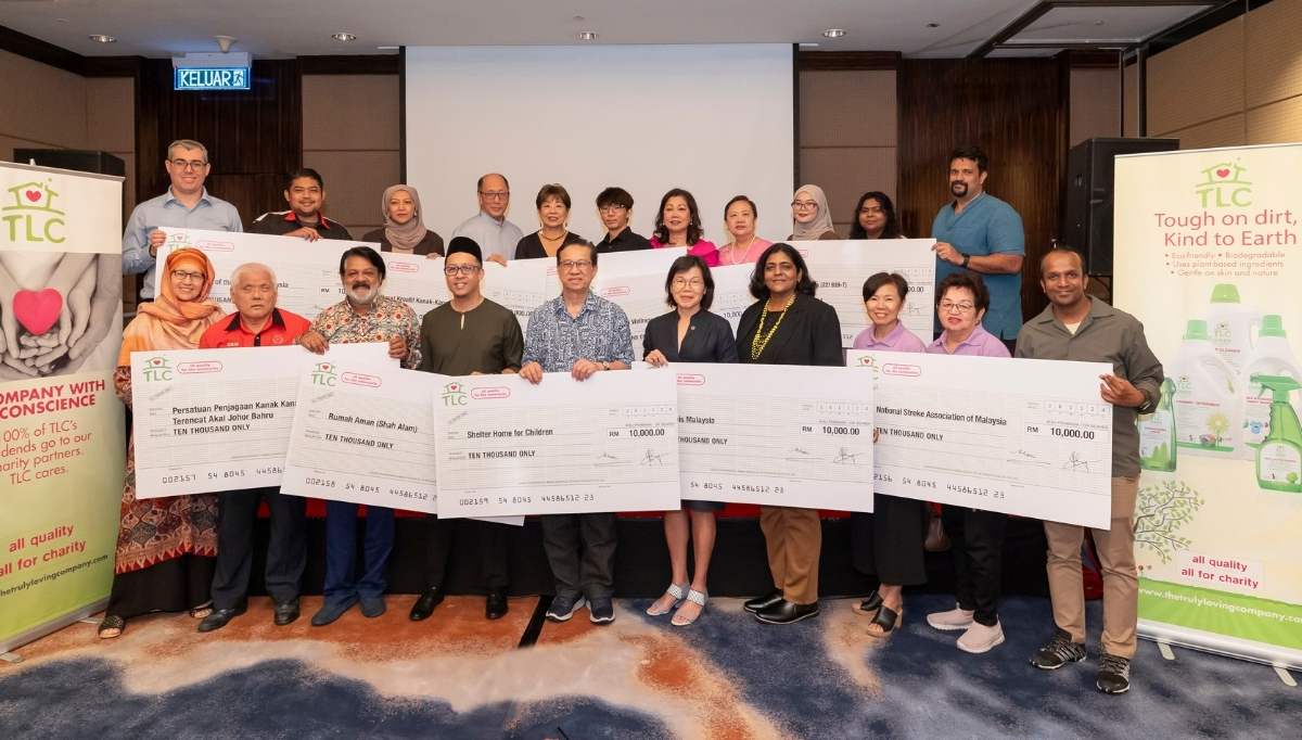Group photo of TLC CEO Ms. Julia Chong and Co-Director Mr. Khaw Chay Tee with representatives from both the 2024 and 2025 beneficiary organisations on stage