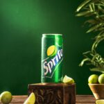 a can of sprite on a wooden stand with limes